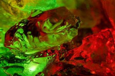 Close-up of colorful translucent crystals in red and green lighting.の写真素材
