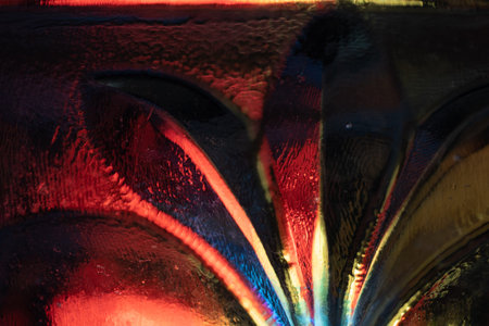 Abstract close-up of colorful textured glass with floral pattern.