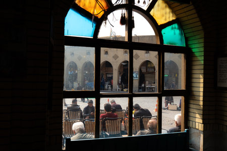 View through a window of people sitting outside a traditional building.の写真素材