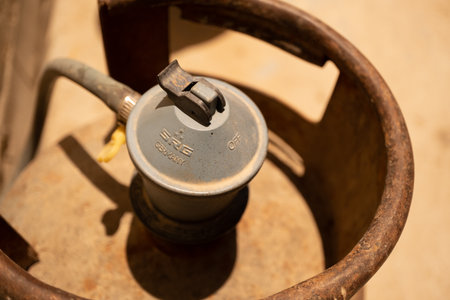 A close-up view of a gas cylinder valve, showing the handle and markings, with a rustic backgroundのeditorial素材