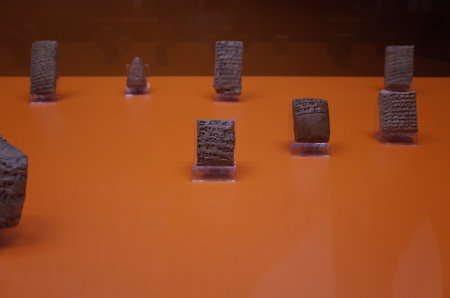 Ancient clay tablets with cuneiform inscriptions displayed on an orange backgroundのeditorial素材