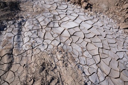 Aerial view of cracked dry earth surface, showing patterns of drought and soil erosion