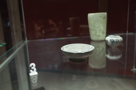 A display case containing various stone artifacts including bowls and vases
