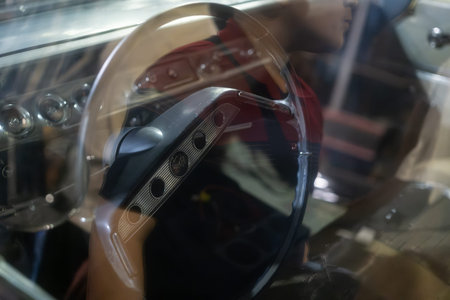 A close-up view of a vintage car steering wheel with reflections, showcasing the interior details...