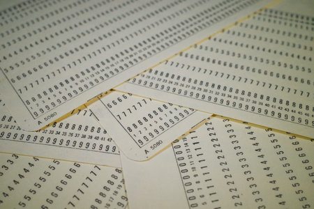 A close-up view of several sheets of paper filled with printed numbers in a grid format. The sheets...