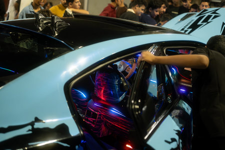 A modified car with colorful interior lighting, surrounded by a crowd of people admiring itのeditorial素材