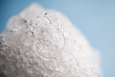 High-Definition Macro Photograph of a Transparent, Foldable Acrylic Intraocular Lens Designed for Micro-Incision Phacoemulsification Surgery on a Frozen Bedの写真素材