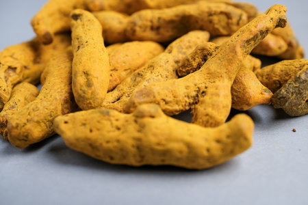 Macro Close-up of Dried Yellow-Orange Turmeric Rhizome Fingers (Curcuma longa) Used as a Potent Spice, Dye, and Natural Supplement.の写真素材