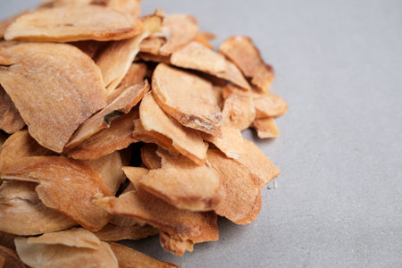 Macro Close-up of Dried Garlic Slices (Allium sativum) Displaying Papery Texture and Light Brown Color Used as a Culinary Spice and Supplement.の写真素材