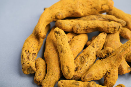 Macro Close-up of Dried Yellow-Orange Turmeric Rhizome Fingers (Curcuma longa) Used as a Potent Spice, Dye, and Natural Supplement.の写真素材