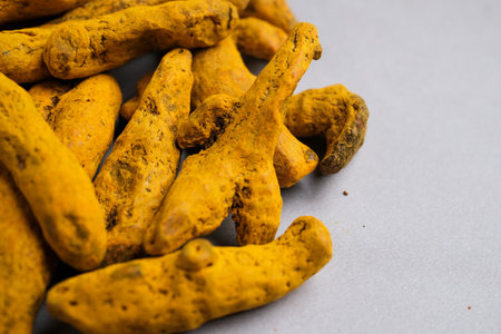 Macro Close-up of Dried Yellow-Orange Turmeric Rhizome Fingers (Curcuma longa) Used as a Potent Spice, Dye, and Natural Supplement.の写真素材