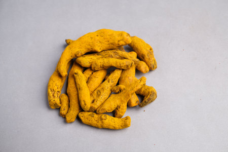 Macro Close-up of Dried Yellow-Orange Turmeric Rhizome Fingers (Curcuma longa) Used as a Potent Spice, Dye, and Natural Supplement.の写真素材