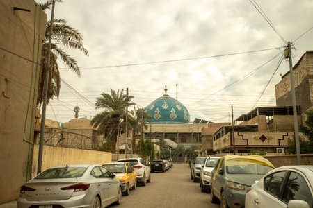 A Scenic View of a Beautiful Blue Domed Mosque with Arabic Calligraphy Located in a Busy Urban Residential Streetのeditorial素材