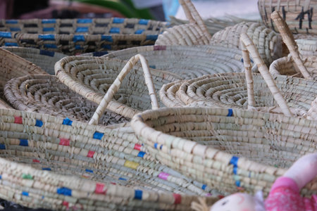 A collection of woven baskets displayed at a market, showcasing intricate patterns and natural...