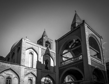 Black-and-white photograph of a historic brick church with arches, towers, and cross-topped spires under clear skyの写真素材
