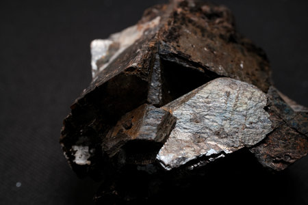 Close-up of rough metallic mineral specimen with jagged edges and reflective silvery surfaces...
