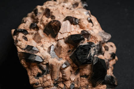 Large beige matrix with glossy black smoky quartz crystals in various sizes embedded on a dark...
