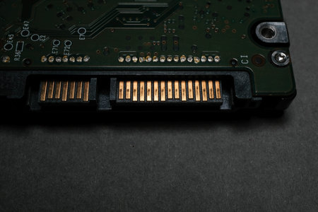 Close-up of a hard drive SATA connector showing gold-plated pins and part of the circuit board on a...