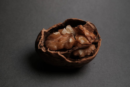 Close-up of a walnut half on dark background, detailed texture and warm tones