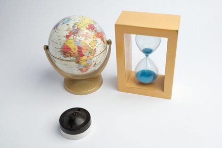 Basra, Iraq - January 21, 2026: World globe and blue sand hourglass symbolizing time and geography
