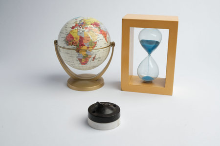 Basra, Iraq - January 21, 2026: World globe and blue sand hourglass symbolizing time and geography