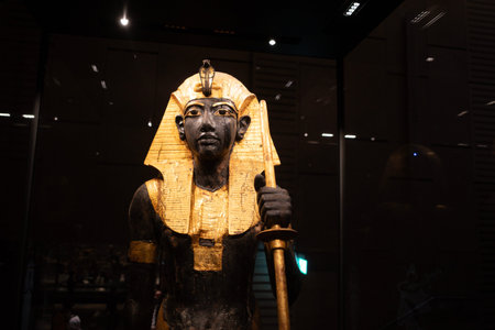 Title: Cairo, Egypt- February 01, 2026: Life sized Gilded Wooden Guardian Statue Of King Tutankhamun...