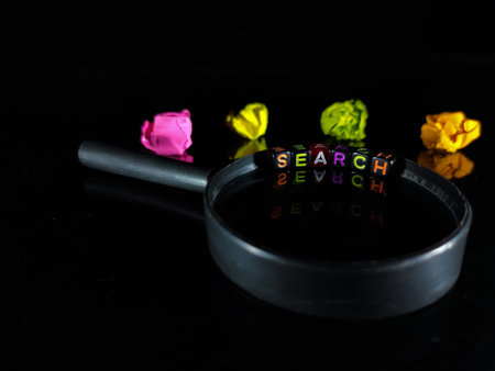 Selective focus.Word SEARCH from a black dice on a magnifying glass with crumpled paper color and ...