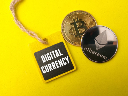 Top view golden bitcoin ,silver ethereum and colored board with text DIGITAL CURRENCY on yellow...