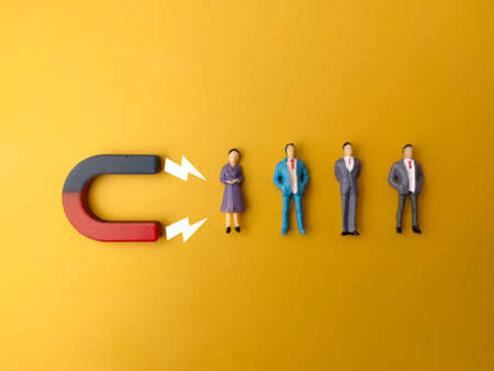 Wooden figures of people and a magnet. Team management concept. Human resources. Promote. Choosing a new leader and hiring employees to work. Headhunting services. Employee dismissal.の写真素材