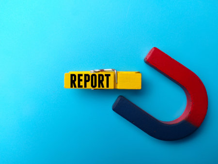 Magnet and wooden clip with text REPORT on blue background.
