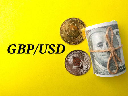 Top view golden bitcoin,silver ethereum and banknotes with text GBP/USD on yellow background.