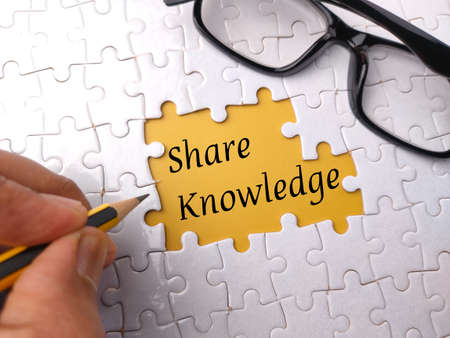 Top view glasses with text ADOPT on a white puzzle background.の写真素材