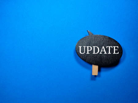 Selective focus.Word UPDATE on a wooden board with blue background.Shot were noise and grain.の写真素材