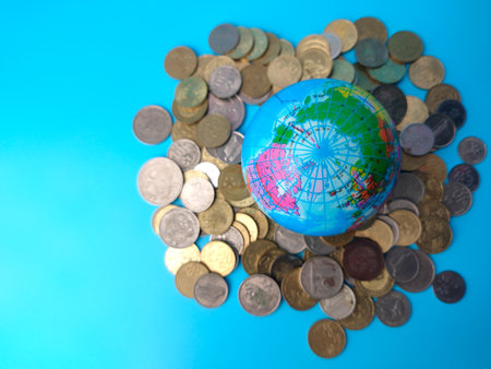 World globe,banknotes and colored wooden cube with word TAX on a blue background.の写真素材