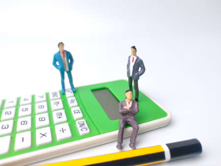 Businessman miniature people and alarm clock on a blue background.Business concept idea.の写真素材