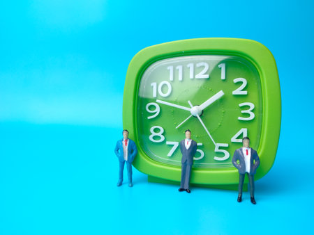 Businessman miniature people and alarm clock on a blue background.Business concept idea.の写真素材