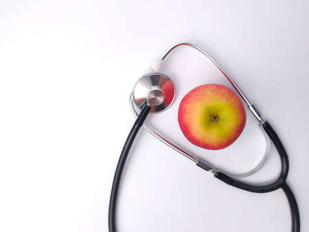 Stethoscope and red apple isolated on a white background. Health care and medical concept idea.の写真素材