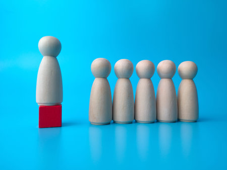 Wooden peg doll on blue background. Leader concept.