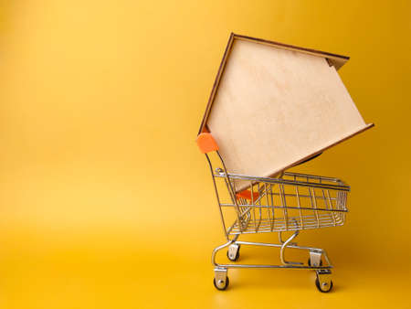 Wooden house and calculator with text Investment Oppurtunity on a yellow background.の写真素材