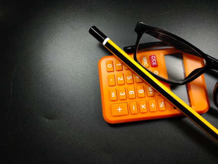 Selective focus of pencil and glasses on black background with copy space.の写真素材