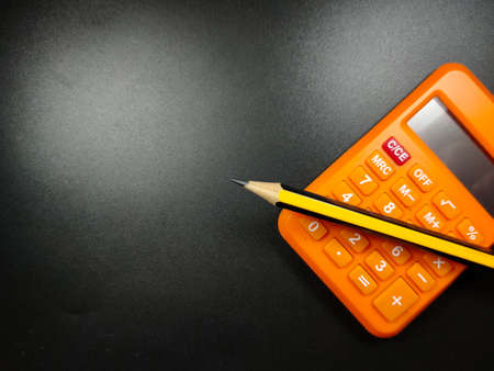 Selective focus of calculator and magnifying glass on black background with Copy space.の写真素材