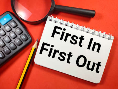 Business concept.Text BRAND LOYALTY with clock,calculator,pen and banknote on red background.の写真素材