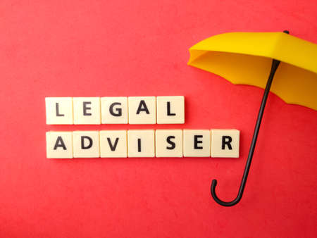 Top view umbrella and toys word with text LEGAL ADVISER on red background.の写真素材
