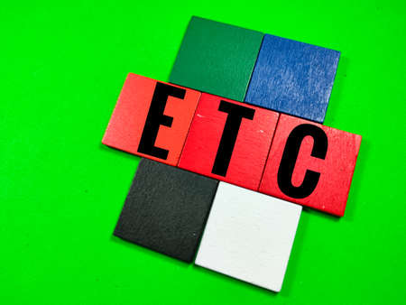 Colorful pieces of wood on green background with text ETC (abbreviation of et cetera) .Business concept.の写真素材
