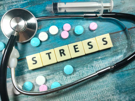 Text STRESS , on a table with a stethoscope,syringe and pills. Medical concept.の写真素材