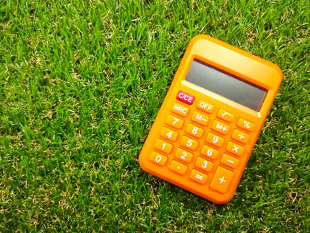 Calculator on green grass background with copy space. Business concept idea.の写真素材