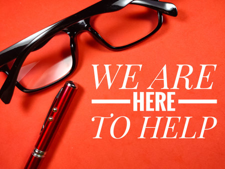 Text WE ARE HERE TO HELP with glasses and pen on red background.