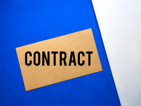 Business concept.Brown card with text CONTRACT on white and blue background.