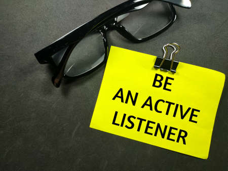 Education concept.Text BE AN ACTIVE LISTENER on colorful paper note with glasses on black background.の写真素材