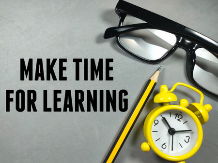 Education concept.Text MAKE TIME FOR LEARNING with pencil,clock and glasses on gray background.